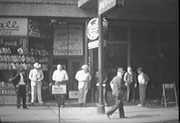 Men standing in front of Passmore's Pharmacy